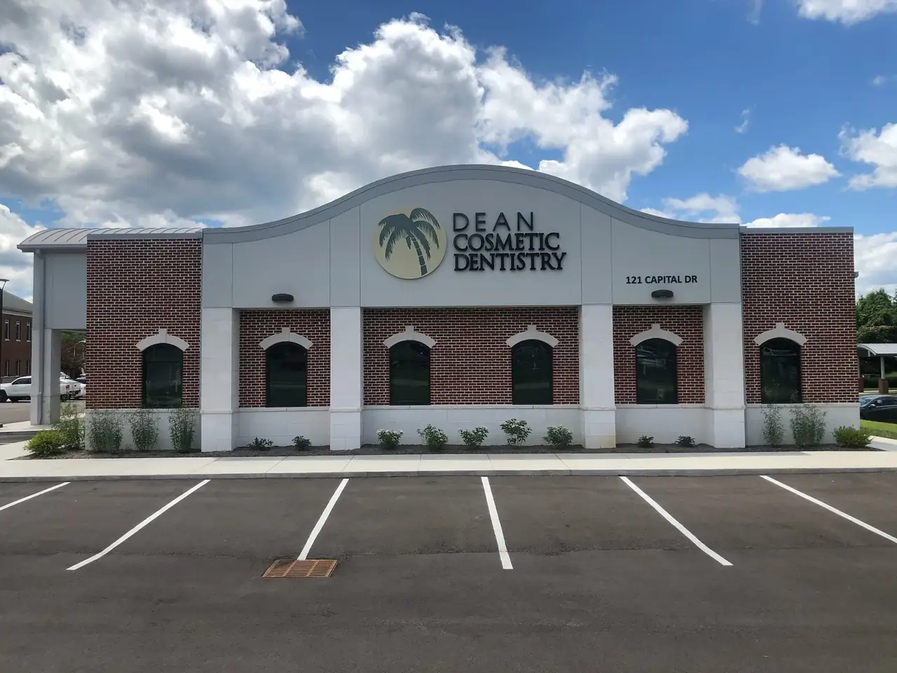 The Dean Cosmetic Dentistry building at 121 Capital Drive, Knoxville, with the palm tree sign on its front.