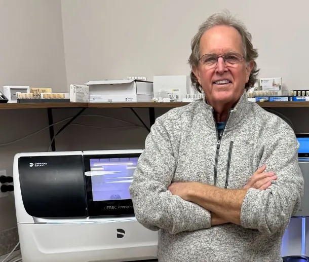 Dr. Donnie Dean in the in-office lab beside the CEREC milling unit.