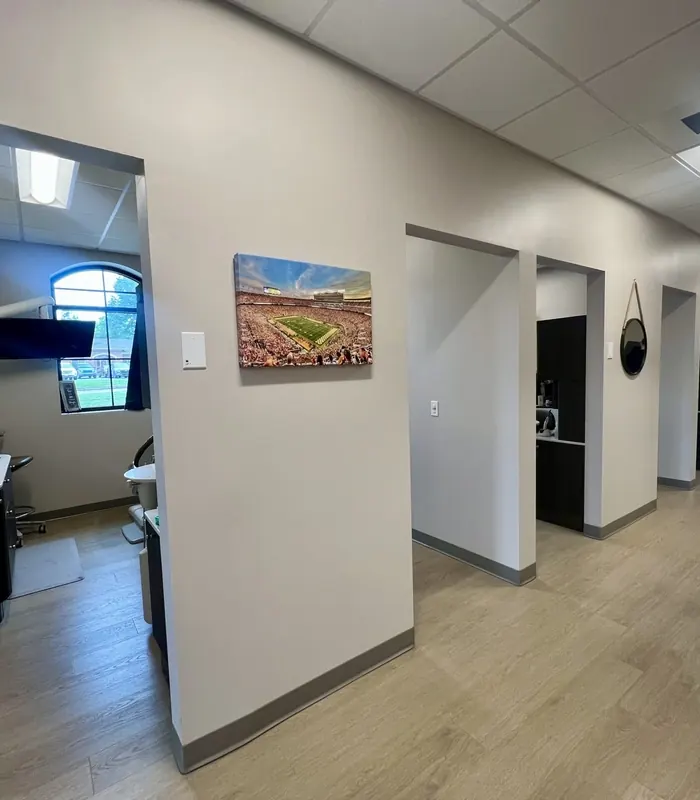 A corridor of treatment rooms, each with artwork outside.
